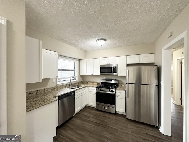 kitchen featuring sink, dark wood-type flooring, stainless steel appliances, white cabinets, and stone countertops