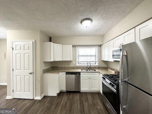 kitchen with stainless steel appliances, sink, white cabinets, and dark hardwood / wood-style flooring