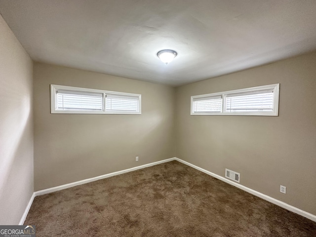 empty room featuring plenty of natural light and carpet