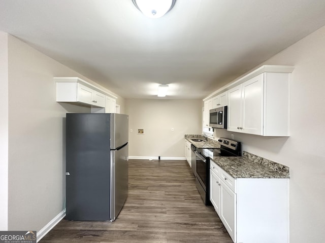 kitchen featuring appliances with stainless steel finishes, sink, white cabinets, and dark hardwood / wood-style flooring