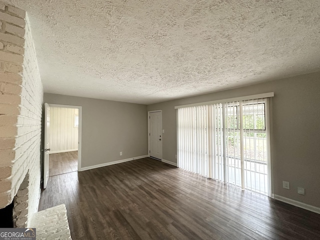 unfurnished living room featuring dark wood-type flooring and a textured ceiling