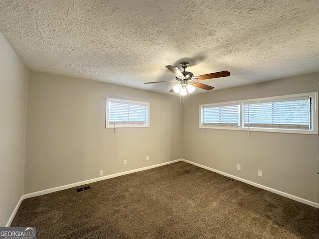 spare room featuring a textured ceiling, ceiling fan, and carpet