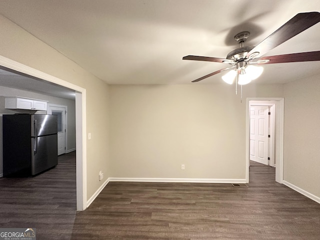 empty room with ceiling fan and dark hardwood / wood-style flooring