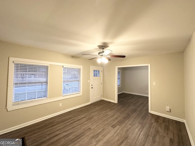 empty room featuring dark wood-type flooring and ceiling fan