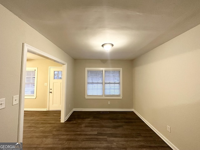 unfurnished dining area featuring dark wood-type flooring