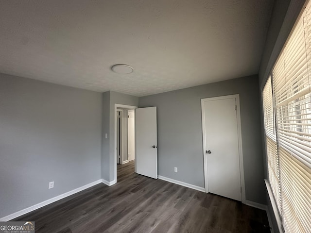 unfurnished bedroom featuring dark hardwood / wood-style floors and a textured ceiling