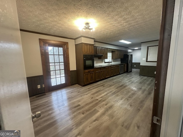 kitchen with hardwood / wood-style floors, stainless steel appliances, and a textured ceiling