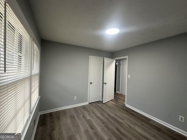 unfurnished bedroom with dark wood-type flooring