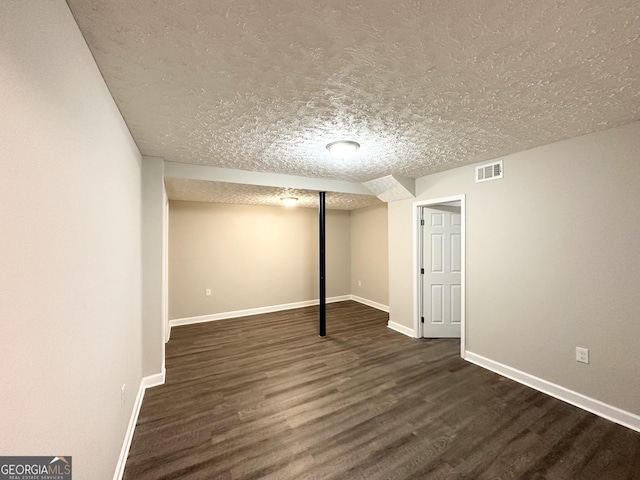 basement with dark hardwood / wood-style floors and a textured ceiling