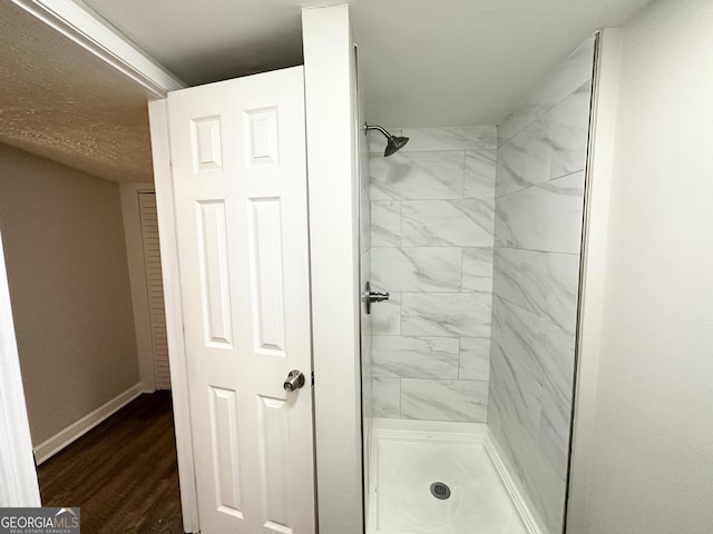 bathroom featuring hardwood / wood-style flooring and tiled shower