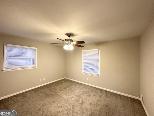 unfurnished room featuring ceiling fan and dark colored carpet