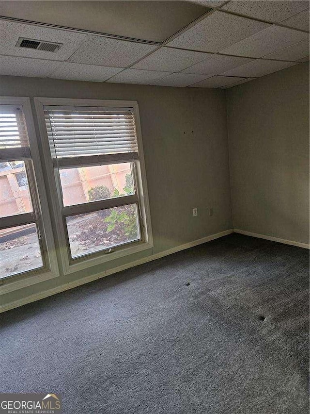 carpeted spare room featuring a paneled ceiling