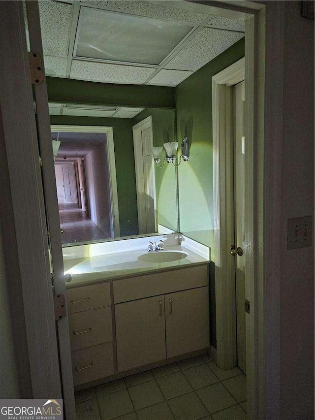 bathroom featuring tile patterned flooring, vanity, and a paneled ceiling