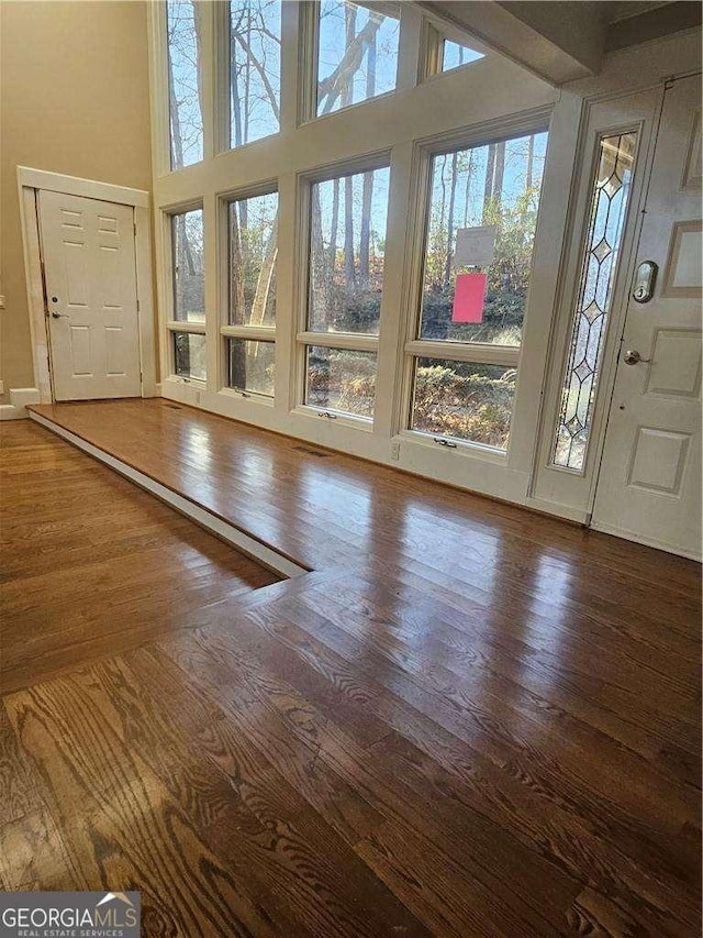 interior space featuring wood-type flooring and a high ceiling