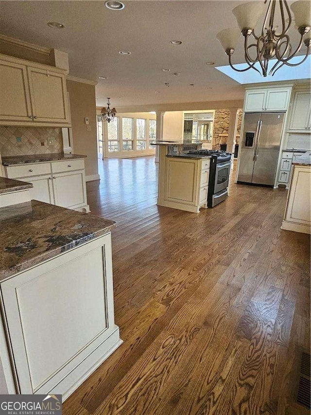 kitchen featuring pendant lighting, light hardwood / wood-style flooring, a chandelier, and appliances with stainless steel finishes