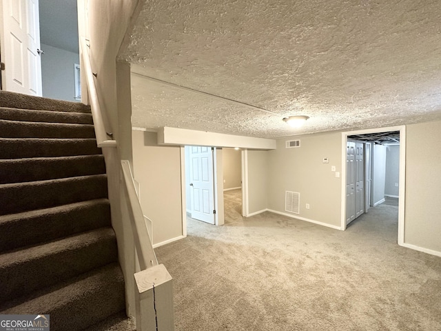 basement with carpet and a textured ceiling