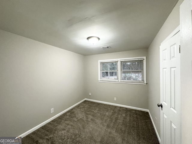 empty room with dark colored carpet