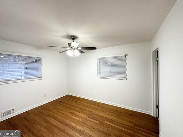 unfurnished room with dark hardwood / wood-style floors and ceiling fan