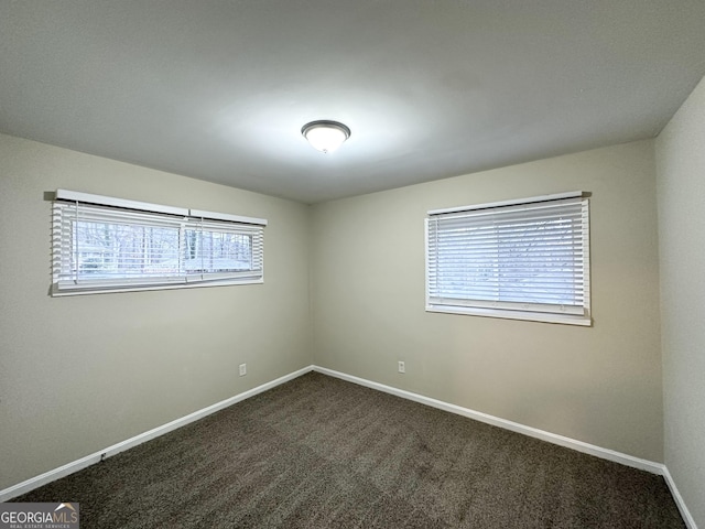 empty room featuring dark colored carpet