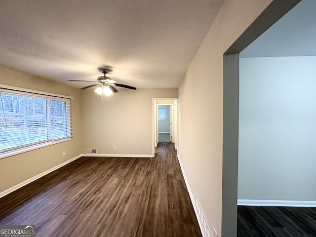 unfurnished room with ceiling fan and dark hardwood / wood-style flooring