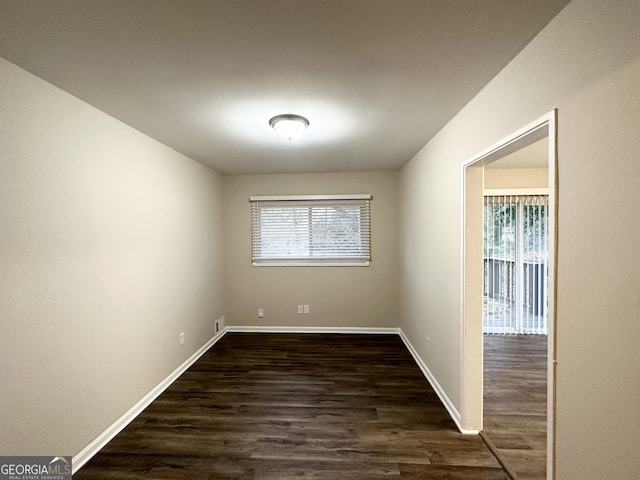 unfurnished room with dark hardwood / wood-style flooring