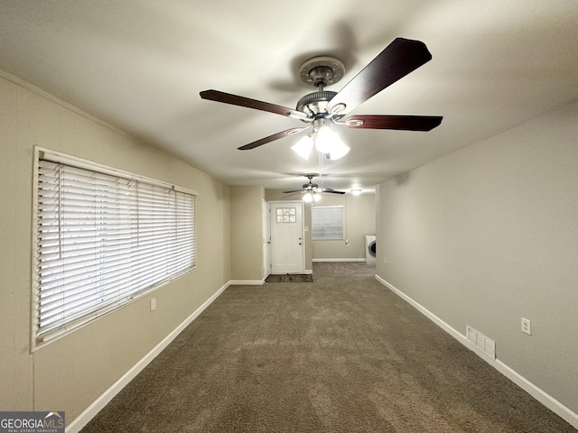 carpeted spare room featuring washer / dryer