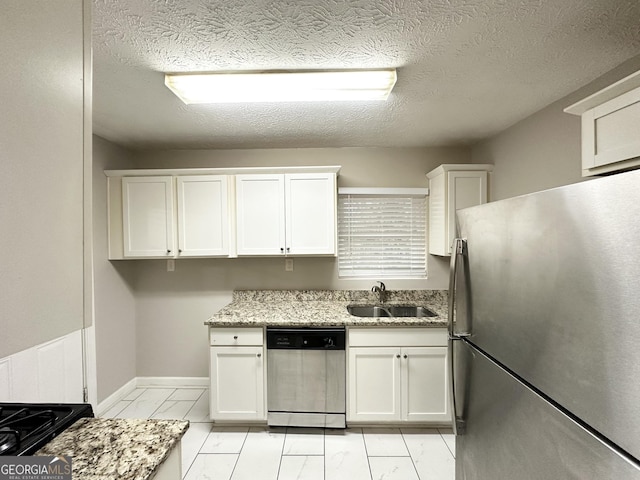 kitchen with light stone counters, stainless steel appliances, sink, and white cabinets