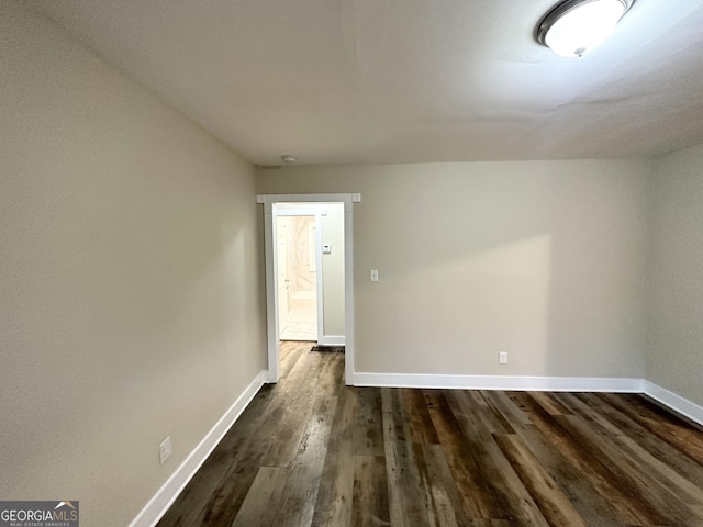 empty room with dark hardwood / wood-style flooring