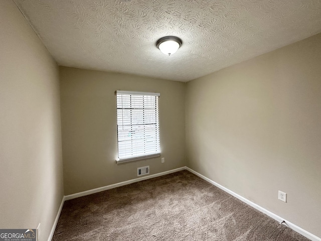 unfurnished room featuring carpet flooring and a textured ceiling