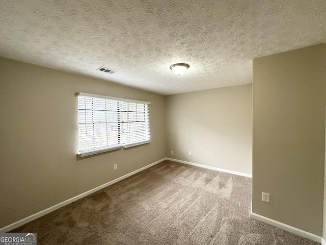 carpeted empty room with a textured ceiling