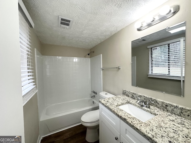 4305 Old Lake Dr, Decatur, GA 30034 - bathroom featuring vanity, wood finished floors, a textured ceiling, healthy amount of natural light, and bathing tub / shower combination