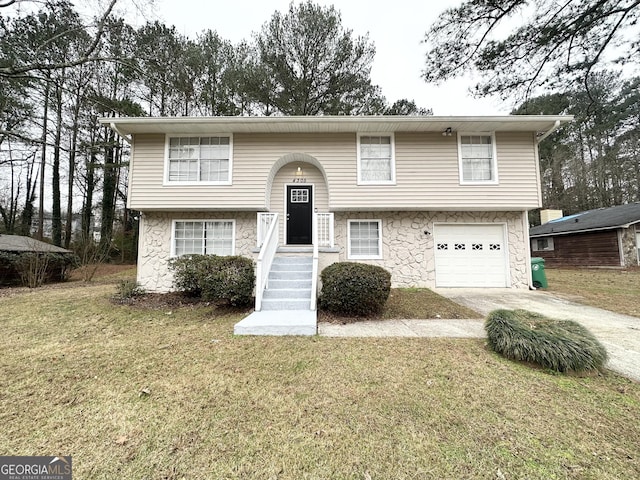 bi-level home featuring a garage and a front yard