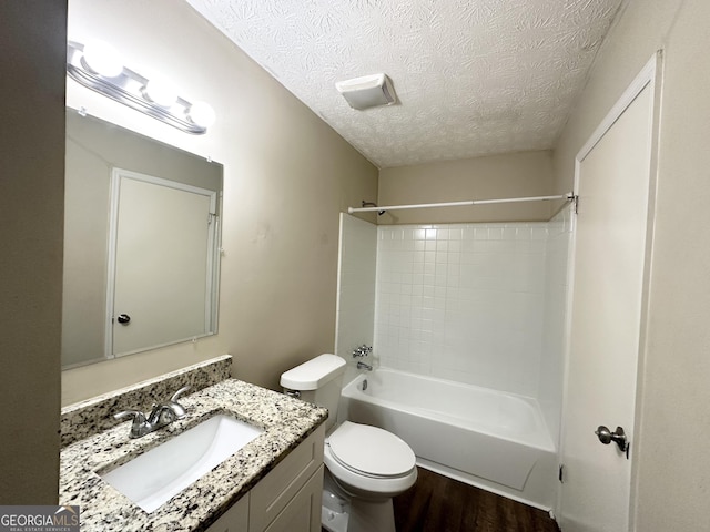 full bathroom featuring hardwood / wood-style floors, vanity, toilet, tub / shower combination, and a textured ceiling