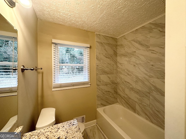 bathroom featuring a textured ceiling and toilet