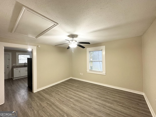 empty room with dark hardwood / wood-style floors and a textured ceiling