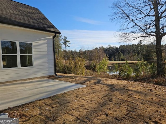 view of yard with a water view and a patio area