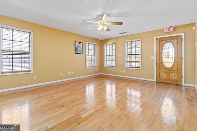 foyer with ceiling fan, a textured ceiling, and light wood-type flooring