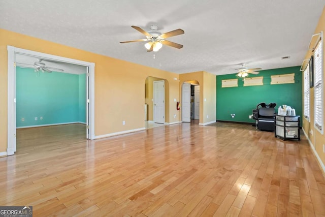 unfurnished living room featuring a textured ceiling, light hardwood / wood-style flooring, and ceiling fan