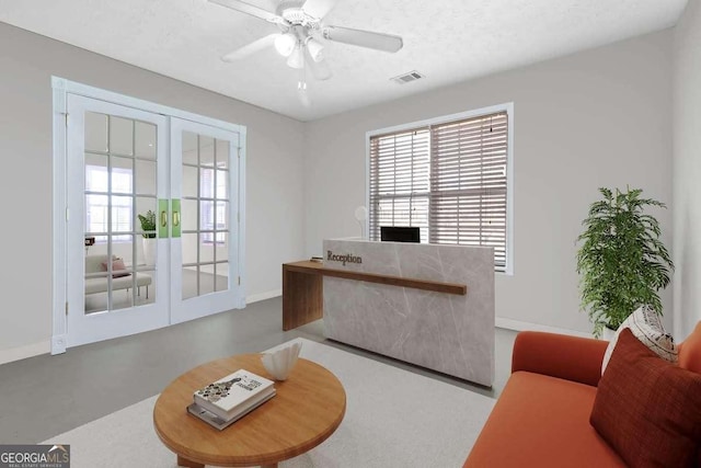 office with a textured ceiling, concrete flooring, french doors, and ceiling fan