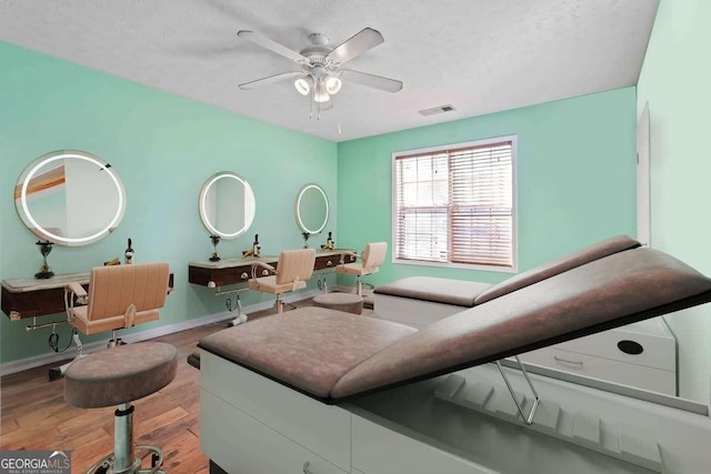 interior space with a textured ceiling, wood-type flooring, and ceiling fan