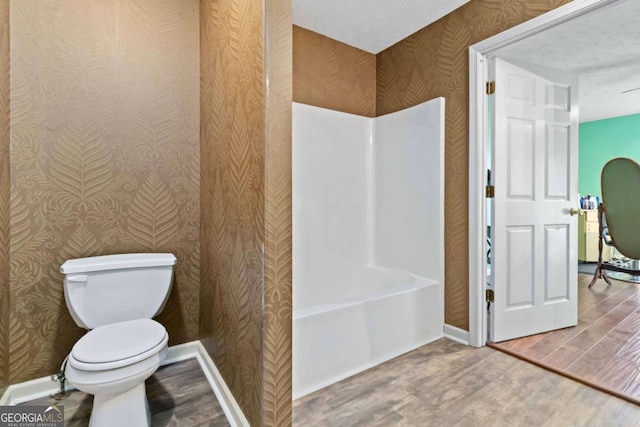 bathroom with wood-type flooring, plus walk in shower, and toilet