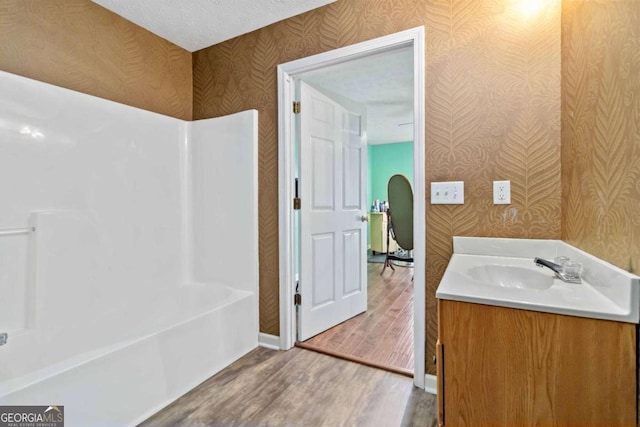 bathroom featuring hardwood / wood-style flooring, vanity, and a textured ceiling