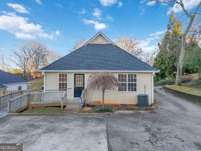 rear view of property with a wooden deck and cooling unit