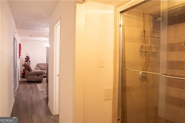 bathroom with hardwood / wood-style floors and a shower with shower door