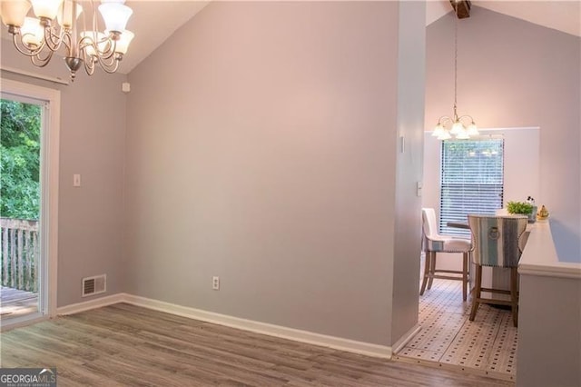 dining space with plenty of natural light, a notable chandelier, baseboards, and wood finished floors