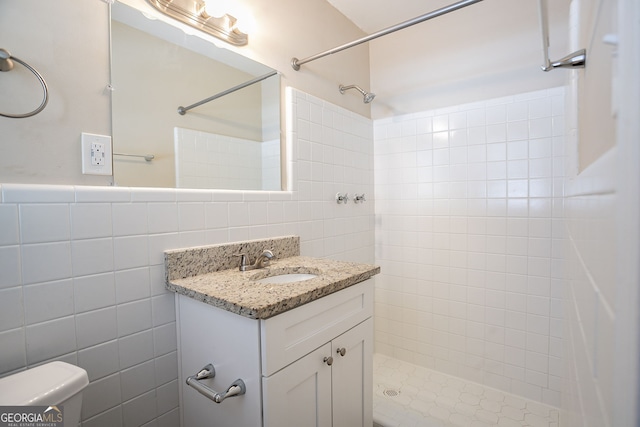 bathroom with vanity, tile walls, and a tile shower