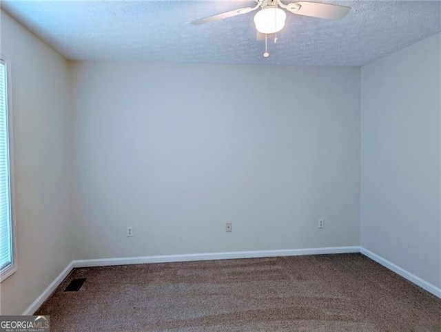 carpeted spare room featuring ceiling fan and a textured ceiling