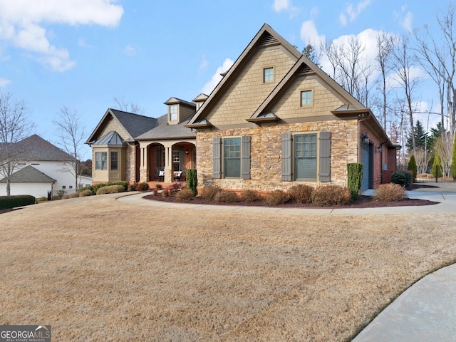 craftsman-style home featuring a porch and a front yard