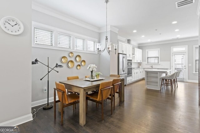 dining area featuring crown molding, dark hardwood / wood-style flooring, and a chandelier