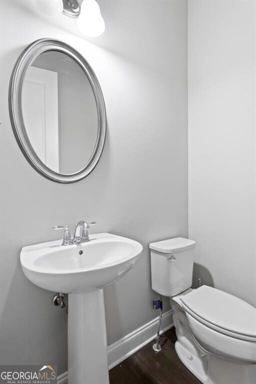 bathroom with wood-type flooring and toilet